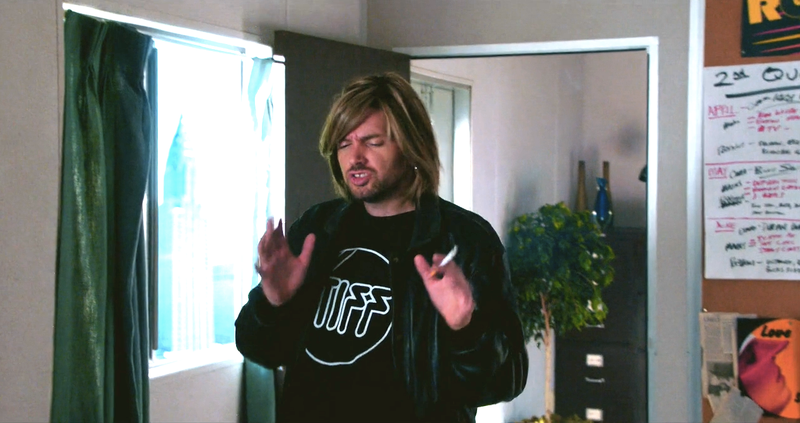 Dave (Paul Scheer) in a Stiff Records t-shirt